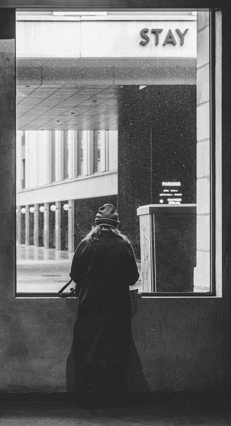 blanco y negro persona abrigo ventana de cristal