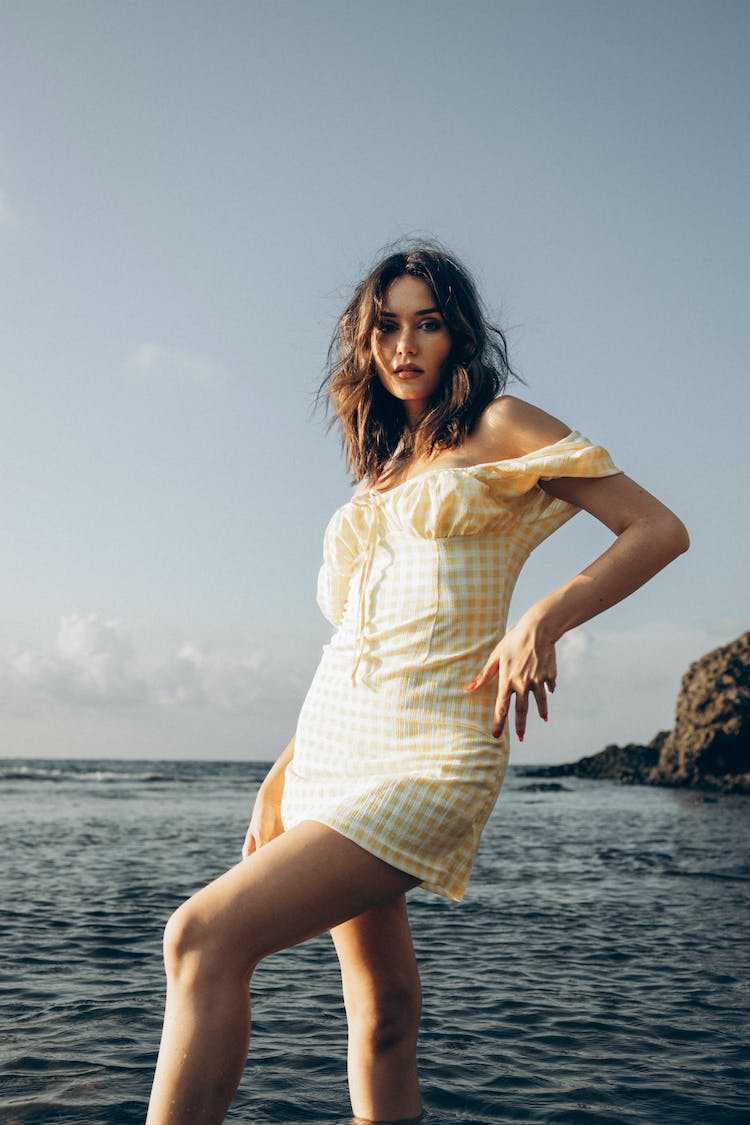 mujer llevando amarillo vestido cerca mar