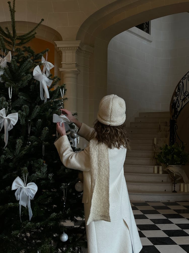 mujer adornos decorando arbol de navidad