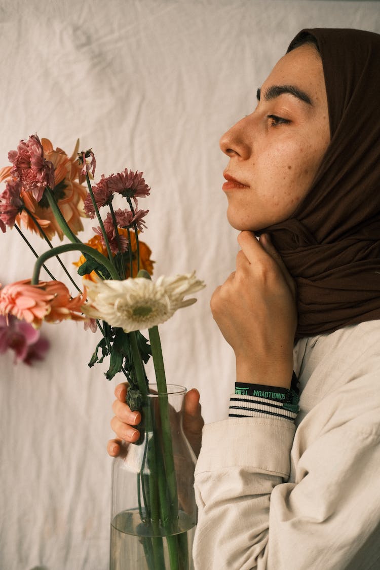 mujer flores cara sujetando