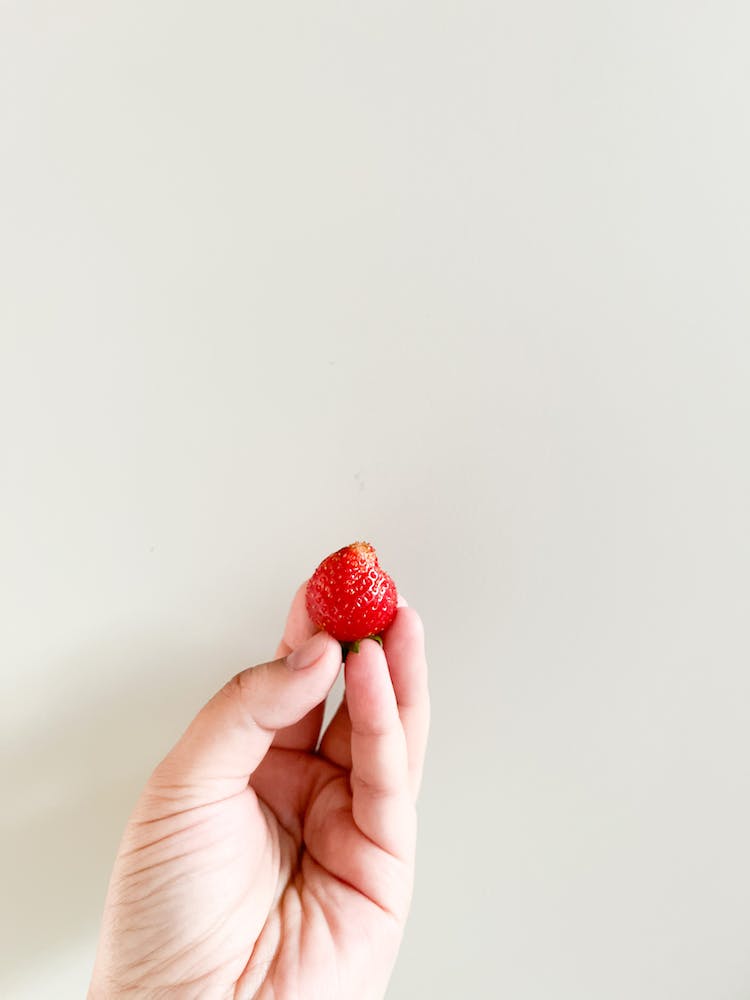 mano sujetando fruta fresa