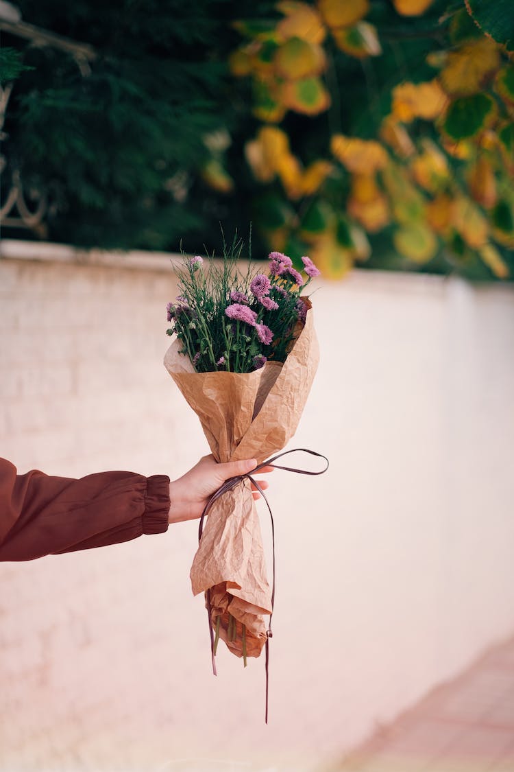 mano ramo de flores bokeh sujetando