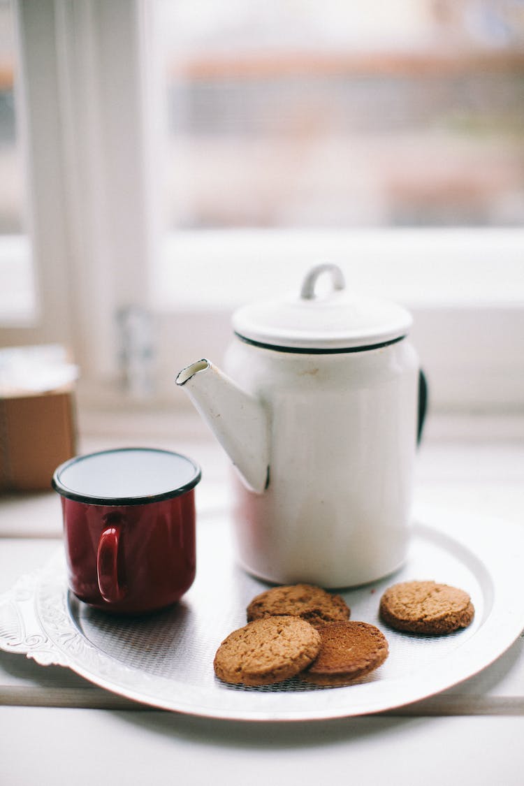 tetera blanca taza roja y galletas