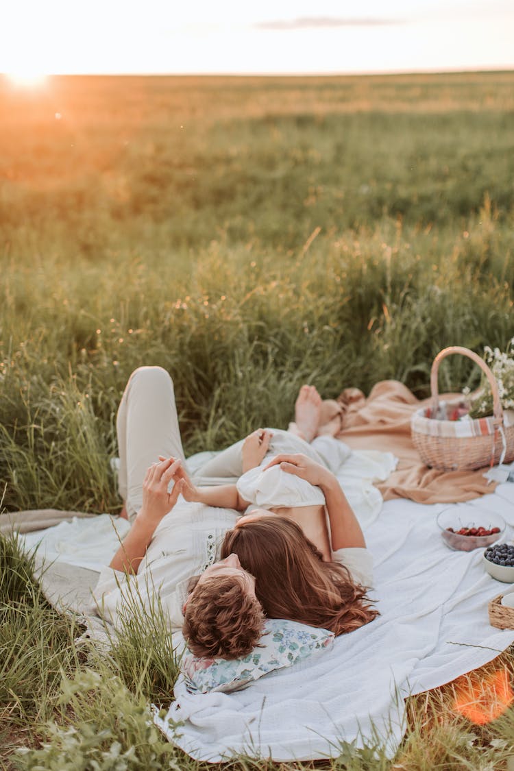 hombre y mujer acostado en un manta de picnic