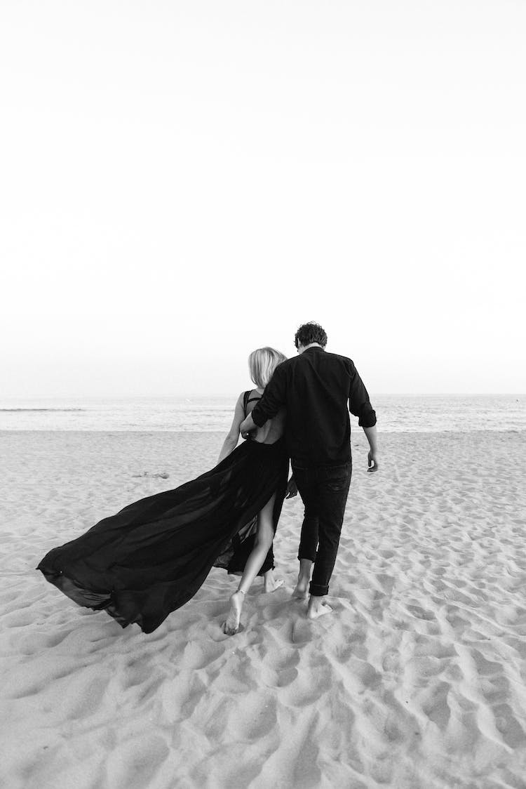 hombre y mujer caminando en la playa