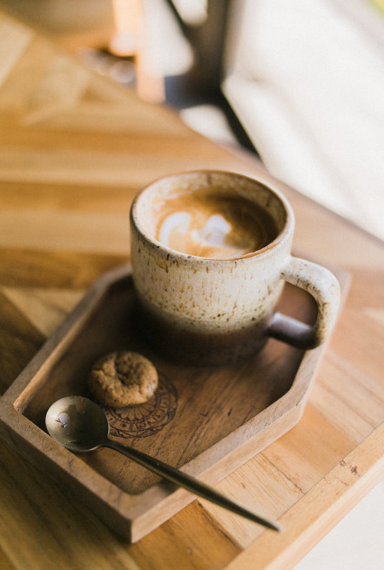 cuchara con galleta por taza de cafe