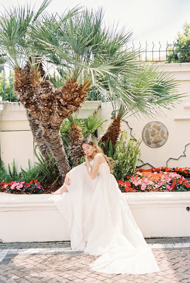 mujer en vestido de novia blanco de pie junto al arbol de navidad verde y marron