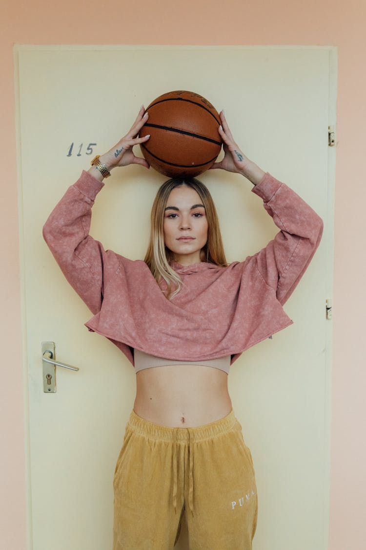 mujer en bata rosa con baloncesto