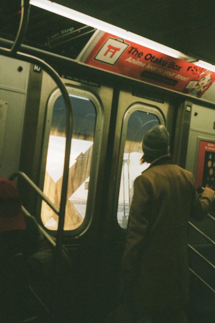 hombre de chaqueta negra sentado en el asiento del tren