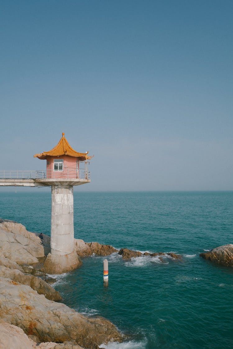 faro torre cielo azul aguas tranquilas